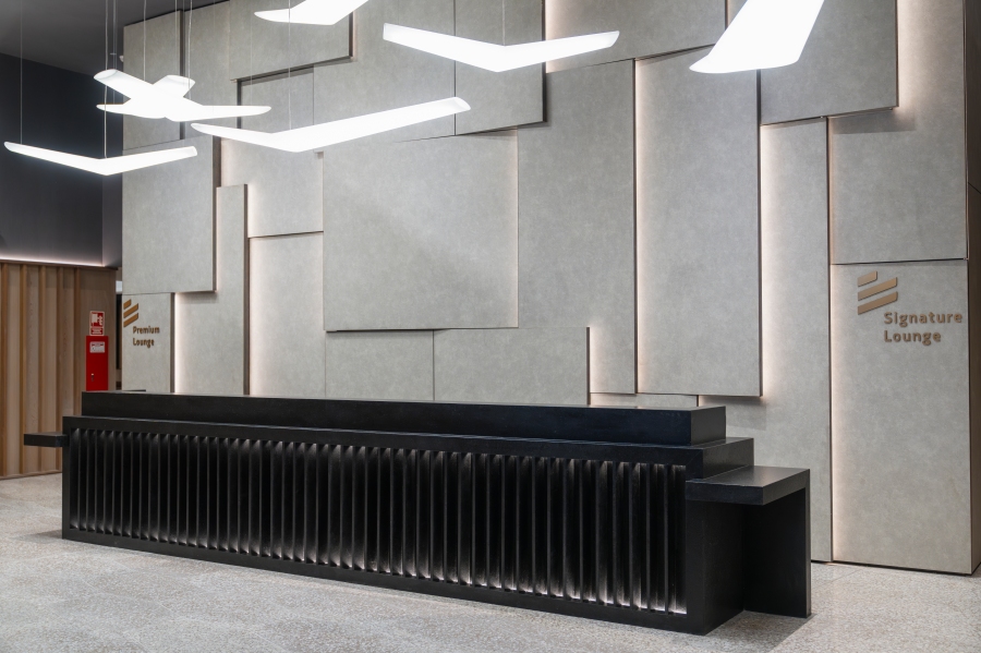 Vue intérieure du salon Signature Latam avec un bureau d'enregistrement moderne et un design mural contemporain.